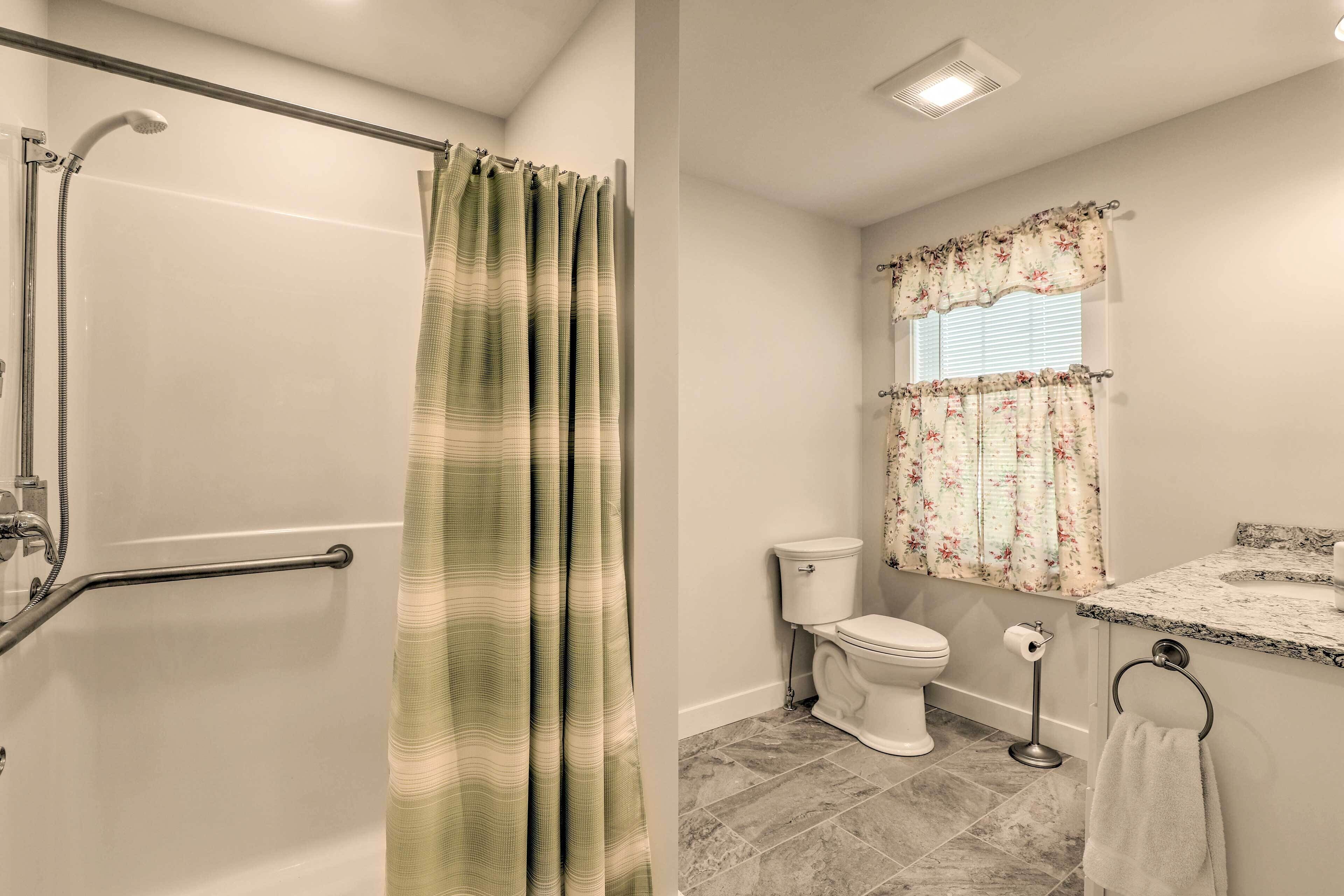 A bathroom with a shower, toilet, and sink.