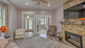 A spacious living room with a fireplace, a ceiling fan, and a view into the dining area. - < 1 Mi to Dtwn Ludington: Bright Lower-level Unit (Ludington)
