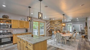 A modern kitchen with wooden cabinets, granite countertops, and stainless steel appliances. - < 1 Mi to Dtwn Ludington: Bright Lower-level Unit (Ludington)
