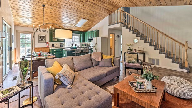 A spacious living area with a large sectional sofa, a wooden coffee table, and a staircase leading to an upper level. - Calming Twin Peaks Family Retreat w/ Views! (Twin Peaks)