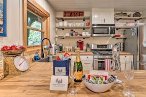 Una cocina con estantes de madera, una balanza, una botella de champán y un bol de aperitivos.