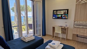 A hotel room with two beds, a desk, a TV, and a view of the sea. - New apartment 100 meters from the sea (Nerano)