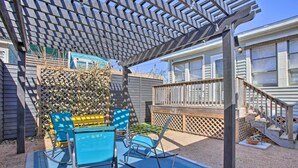 Un patio couvert agrémenté d’une pergola, de meubles d’extérieur et d’une terrasse en bois.