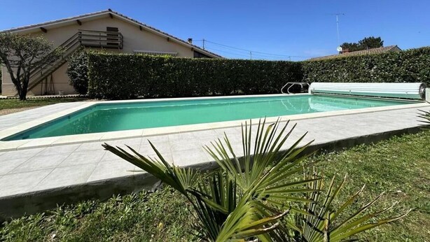 A rectangular swimming pool with a tiled deck, surrounded by a well-maintained hedge and a grassy area. - Les tilleuls - SOUSTONS (SOUSTONS)