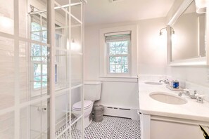 A bathroom with a toilet, bidet, and two sinks.