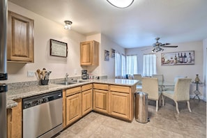 A kitchen with wooden cabinets, a dishwasher, a sink, and a dining area with chairs and a table. - Walkable Location! Las Vegas Apt: 11 Mi to Strip (Las Vegas)