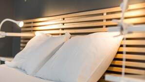 A bed with white linens and a wooden headboard. - Villa Cassora - Herm (HERM)