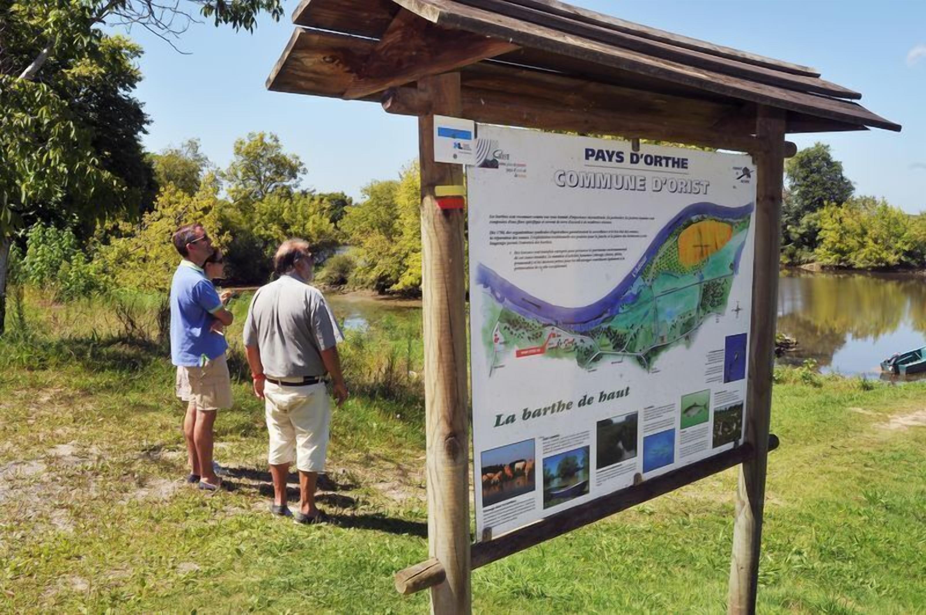 A wooden signboard with a map and text, likely providing information about the area.