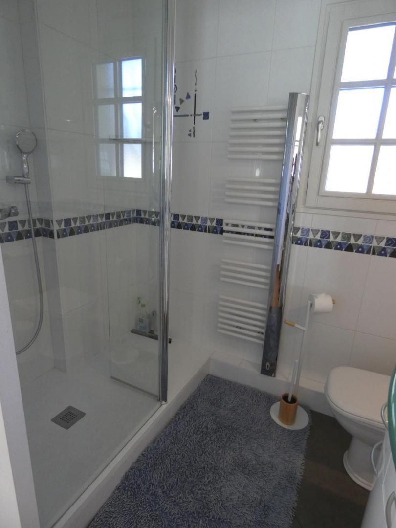 Une salle de bain avec une douche à parois de verre, des toilettes et un bidet.