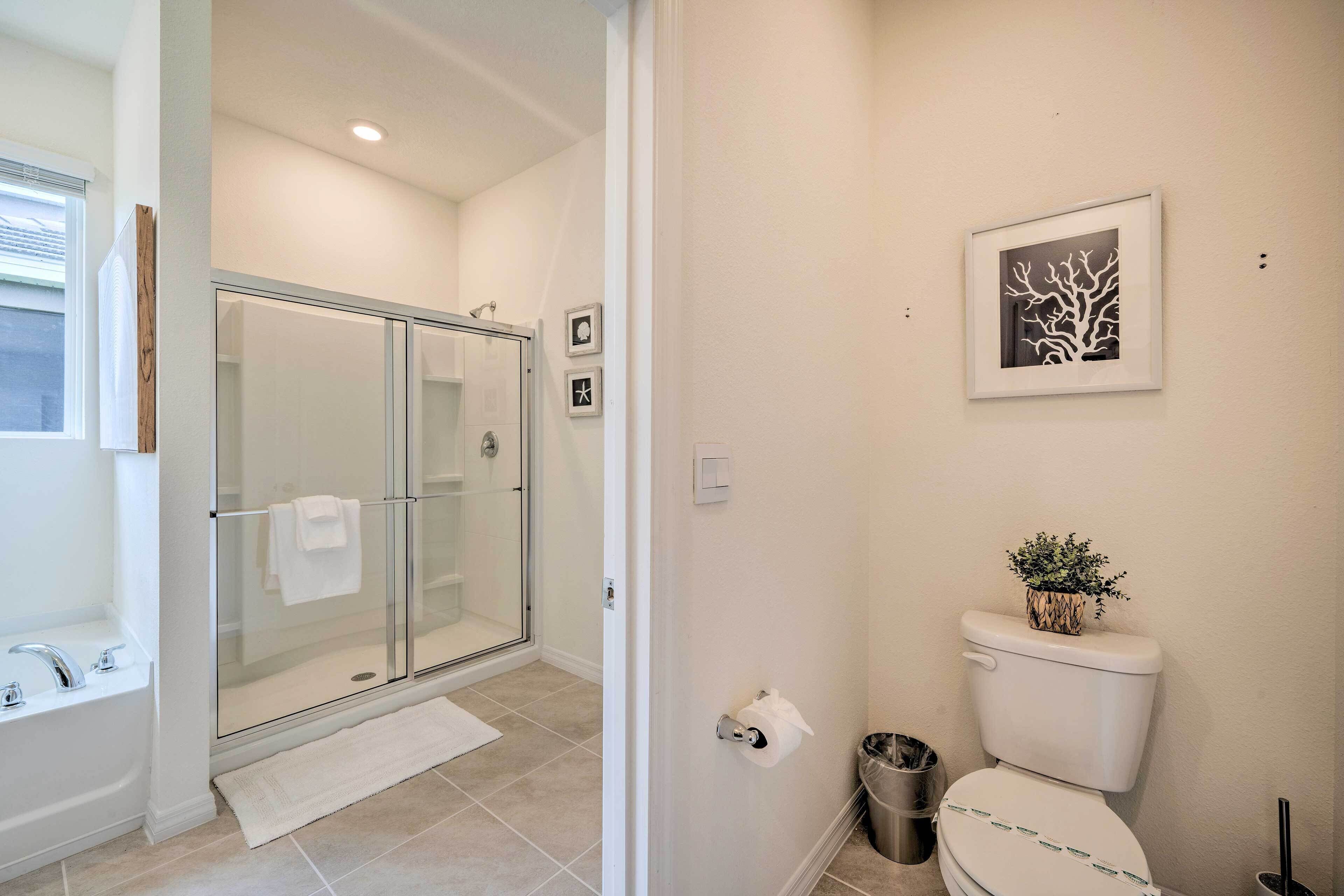 A modern bathroom with a glass-enclosed shower, a toilet, and a sink.