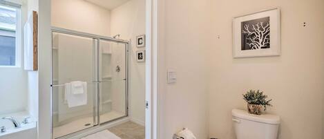 A modern bathroom with a glass-enclosed shower, a toilet, and a sink.