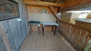 A wooden interior with a table and chairs, a window with a view, and a wooden staircase. - Cozy Alpine Apartment near Lake Bohinj,  Free Bikes & No Extra Fees (Bohinjska Bistrica)