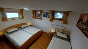 A room with two beds, a window, a radiator, and a painting on the wall. - Cozy Alpine Apartment near Lake Bohinj,  Free Bikes & No Extra Fees (Bohinjska Bistrica)