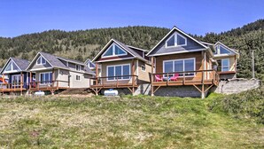 Une rangée de chalets en bois dotés de balcons, situés au pied d’une colline boisée.