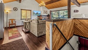 A spacious living area with a wooden ceiling, a fireplace, a couch, and a dining table. - 1 Mi to Slopes: Big Bear Ski Haven w/ Hot Tub (Big Bear Lake)