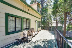 A wooden deck with Adirondack chairs and a bench, surrounded by a green fence and trees. - All-season Crestline Escape - 2 Mi to Lake! (Crestline)