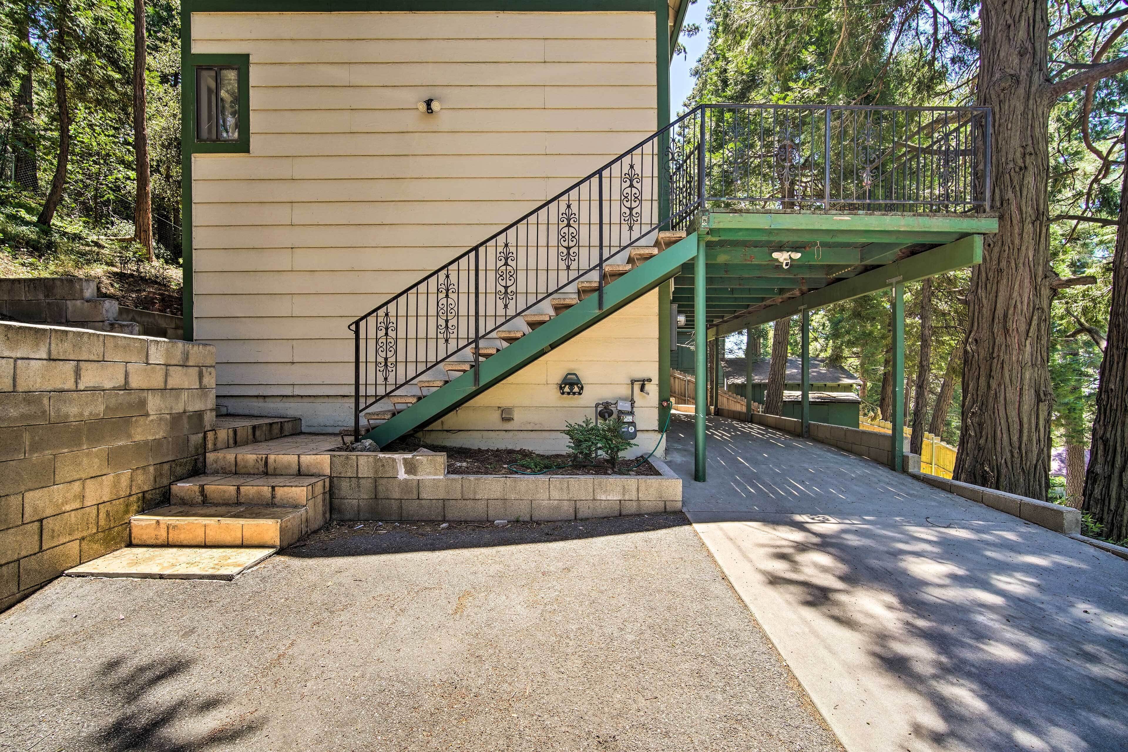 Una casa con una escalera verde que lleva a un porche cubierto.