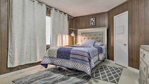 A bedroom with a bed, a nightstand, a dresser, and a window with curtains. - Springfield Vacation Rental: 1 Mi to Downtown (Springfield)