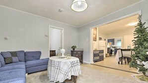 A living room with a blue sofa, a round table with a plaid tablecloth, and a small Christmas tree. - Springfield Vacation Rental: 1 Mi to Downtown (Springfield)