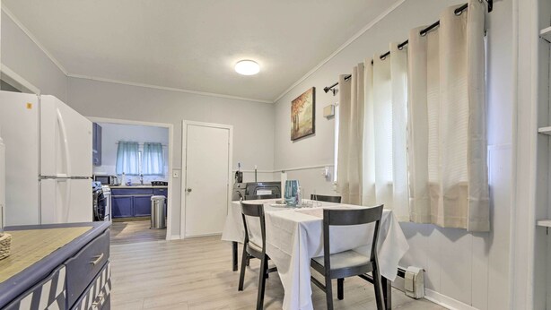A compact kitchen with a refrigerator, microwave, and sink. A dining table with chairs is set up in the center. - Springfield Vacation Rental: 1 Mi to Downtown (Springfield)