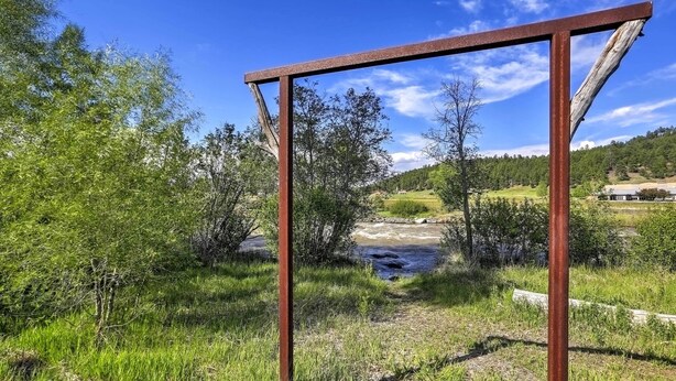 A metal structure in a natural setting with a river and greenery in the background. - Chic Pagosa Springs Condo w/ Porch - Walk to Shops (Pagosa Springs)