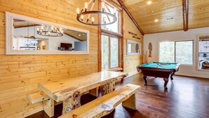 A wooden interior with a pool table, benches, and a chandelier. - Custom-built Gem w/ Kayaks & Games in Big Bear! (Big Bear City)