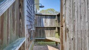 A wooden outdoor shower area with a metal showerhead, a bench, and a brick pathway. - 1 Mi to Beach: Quiet West Dennis Escape w/ Sunroom (West Dennis)