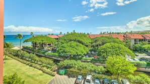 Ett hotellkomplex med flera byggnader, en parkeringsplats och utsikt över havet.