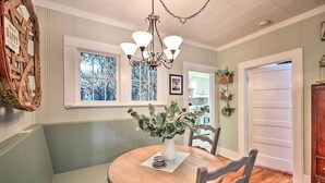 A dining area with a wooden table, chairs, a chandelier, and a vase with flowers. - 1/2 Mi to Hot Springs Nat'l Park: Cottage w/ Patio (Hot Springs)