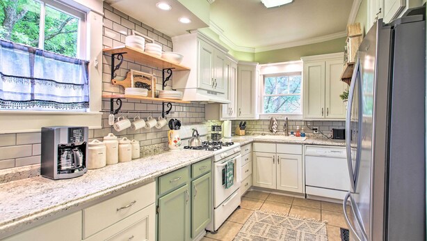A kitchen with white cabinets, a stainless steel refrigerator, and a coffee maker. - 1/2 Mi to Hot Springs Nat'l Park: Cottage w/ Patio (Hot Springs)