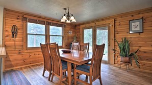 A wooden-paneled dining room with a wooden table and chairs, a chandelier, and a potted plant. - The Pinecone Palace w/ Hiking Trail Access! (Lyons)