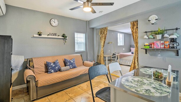 A cozy living room with a sofa, a dining table, and a ceiling fan. - North Las Vegas Studio w/ Fire Pit: 10 Mi to Strip (North Las Vegas)