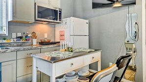 A compact kitchen with white cabinets, a microwave, a refrigerator, and a ceiling fan. - North Las Vegas Studio w/ Fire Pit: 10 Mi to Strip (North Las Vegas)