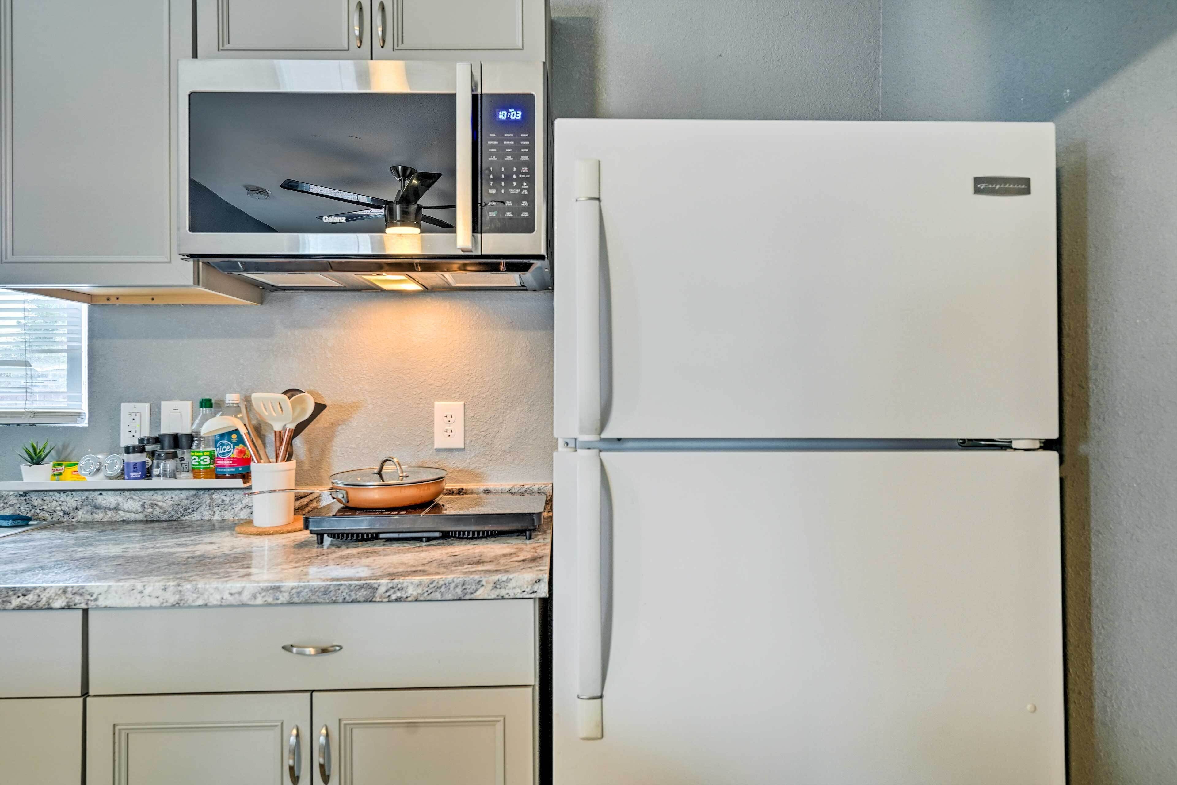 A kitchen with a microwave, oven, and refrigerator.