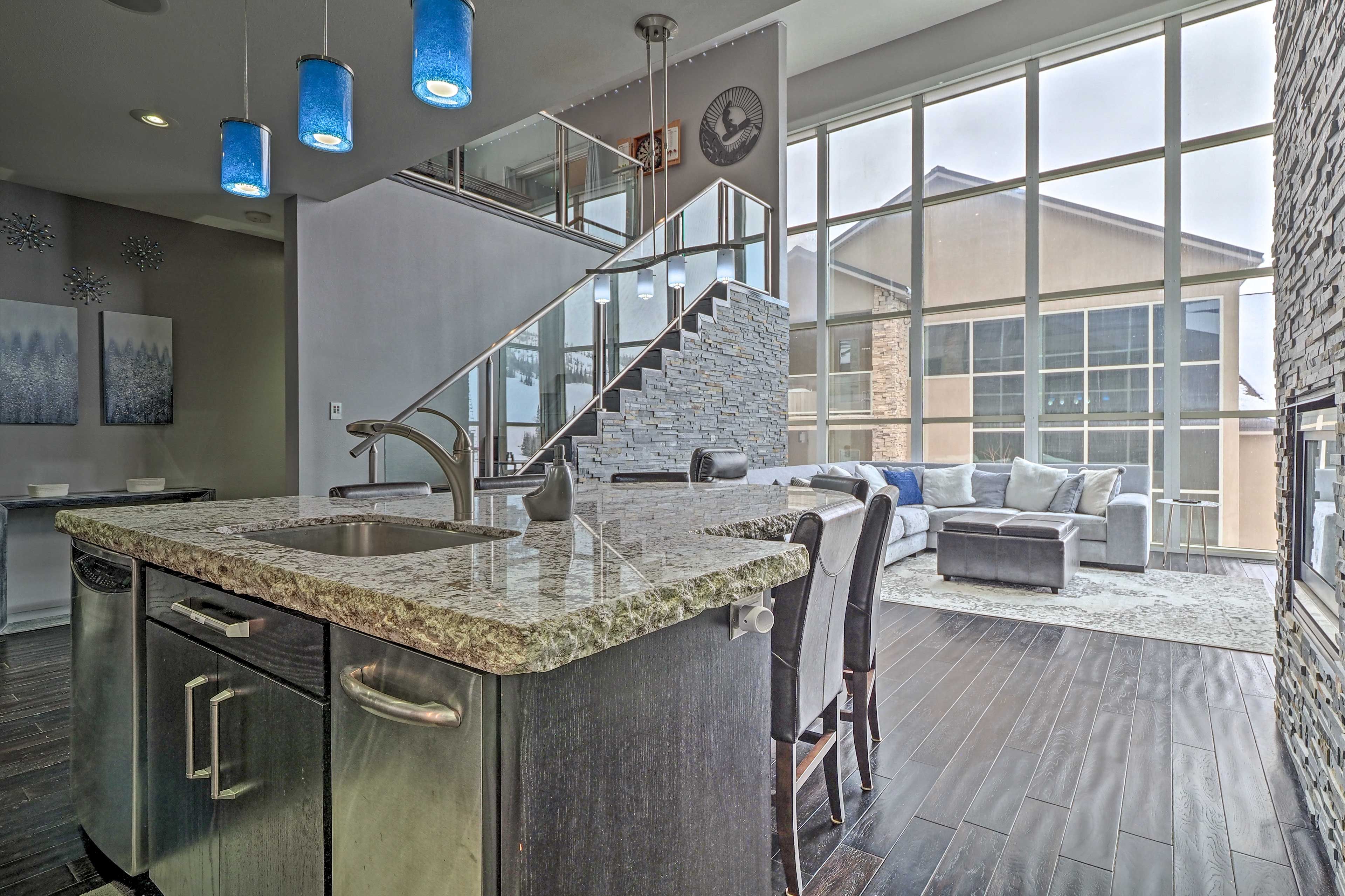 A modern kitchen with granite countertops, stainless steel appliances, and a built-in island.