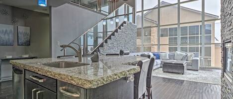 A modern kitchen with granite countertops, stainless steel appliances, and a built-in island.