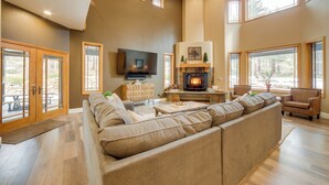 A spacious living room with a large sectional sofa, a fireplace, and a television. - 4 Mi to Ski Mt Rose: Sleek Reno-lake Tahoe Home (Reno)