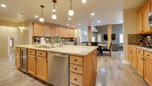 A spacious kitchen with wooden cabinets, a granite countertop, and a central island with a sink. - 4 Mi to Ski Mt Rose: Sleek Reno-lake Tahoe Home (Reno)