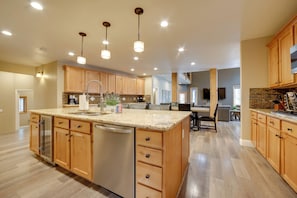 A spacious kitchen with wooden cabinets, a granite countertop, and a central island with a sink. - 4 Mi to Ski Mt Rose: Sleek Reno-lake Tahoe Home (Reno)