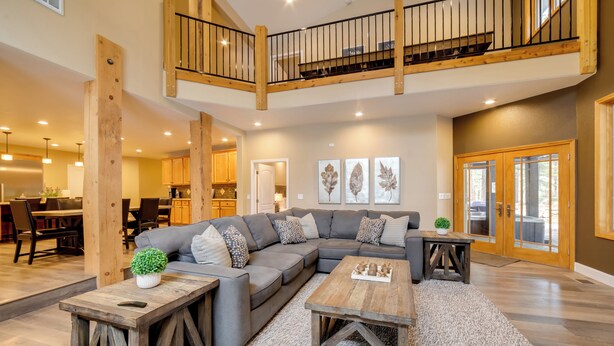 A spacious living area with a large sectional sofa, wooden coffee tables, and a staircase leading to an upper level. - 4 Mi to Ski Mt Rose: Sleek Reno-lake Tahoe Home (Reno)