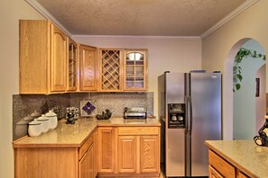 A kitchen with wooden cabinets, a stainless steel refrigerator, a toaster, and a decorative plant. - Packwood Getaway w/ Game Room, Grill & Patio (Randle)
