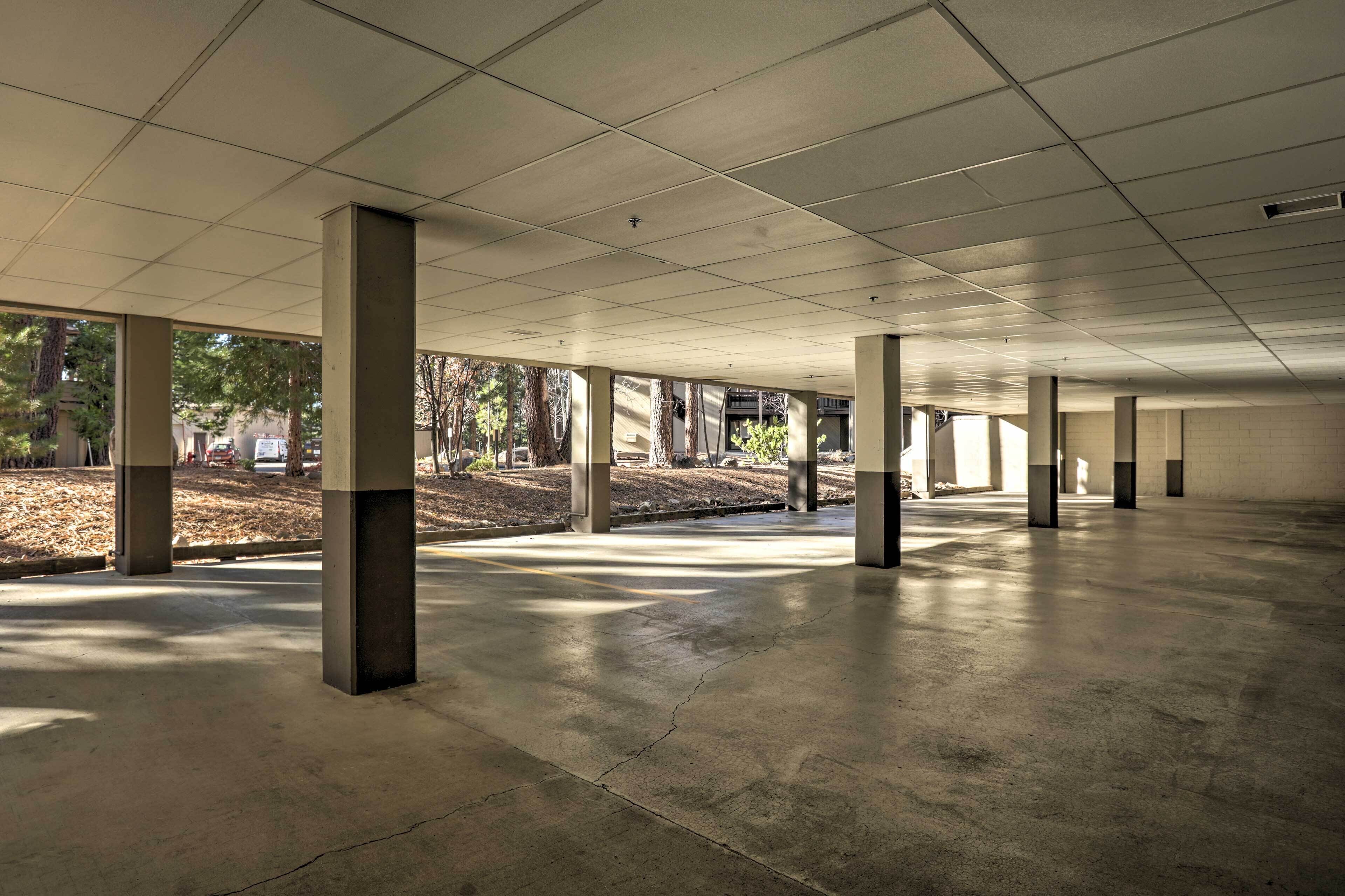 An indoor space with a grid of ceiling tiles, concrete pillars, and a smooth floor.