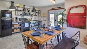 A modern kitchen with a Galanz refrigerator, a stove, and a dining area with a wooden table set for four.