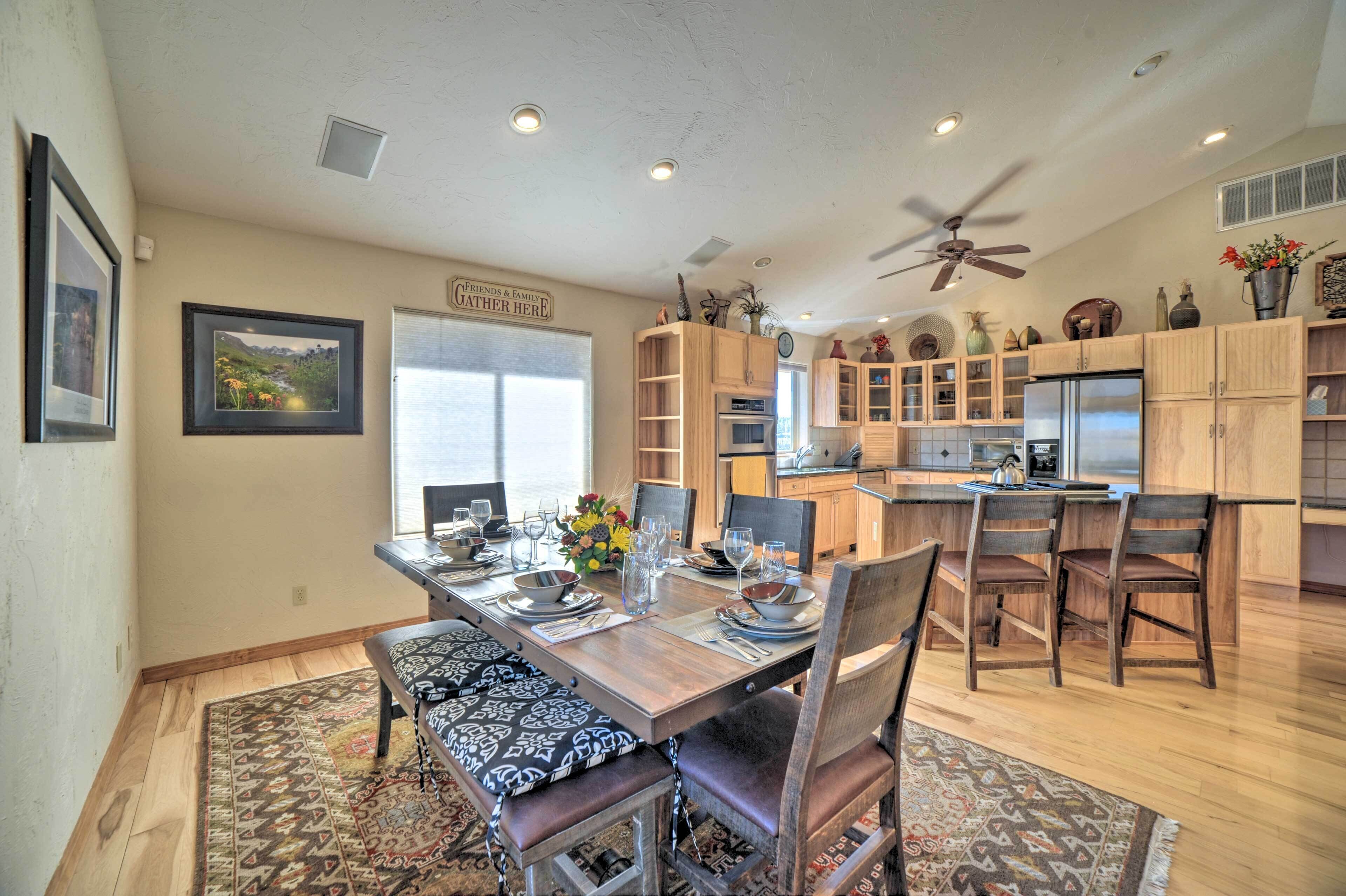 A spacious kitchen with wooden cabinets, a central island, and a dining area with a large table and chairs.