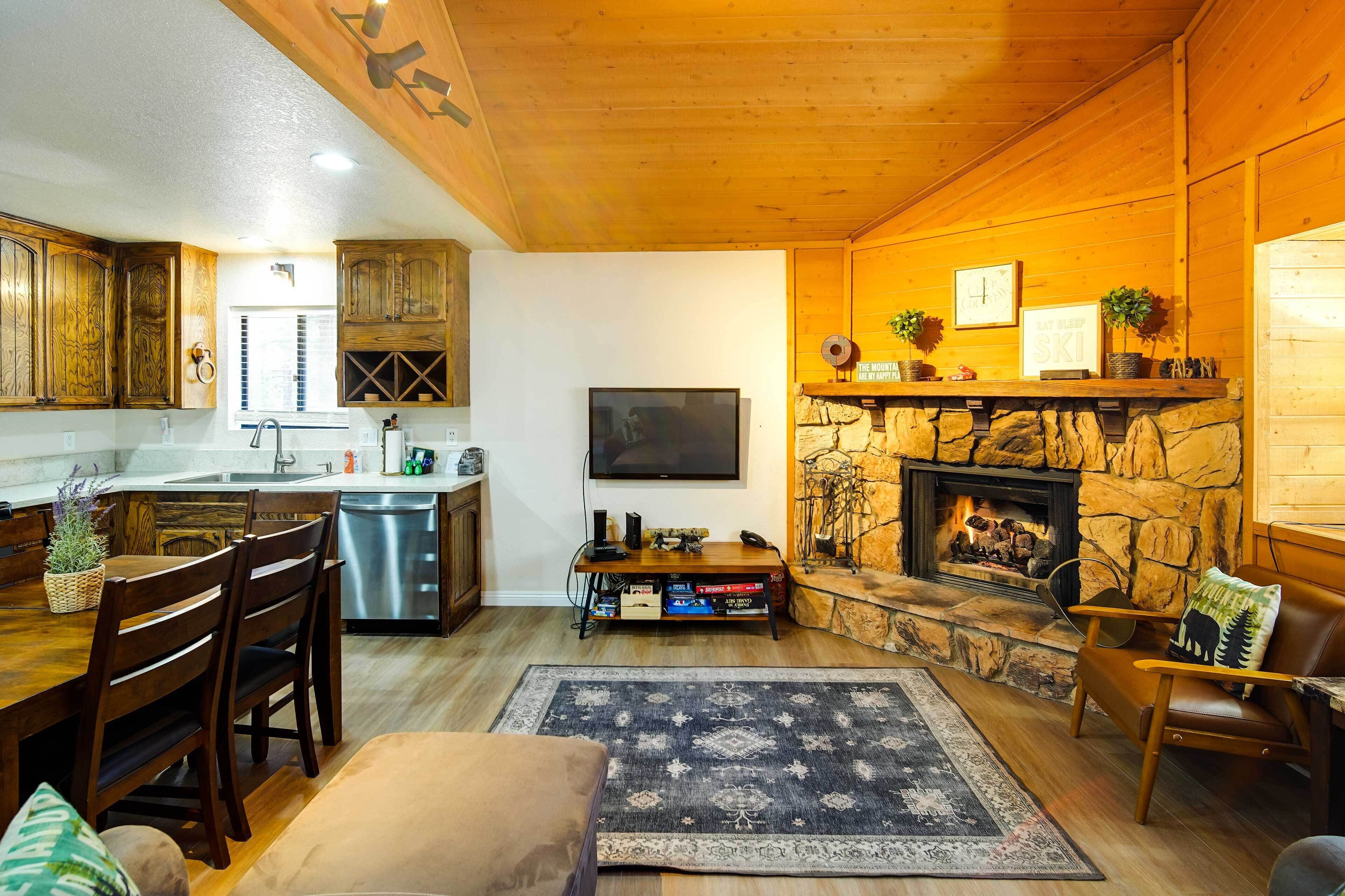 Una sala de estar acogedora con chimenea, muebles de madera y una pared de piedra.