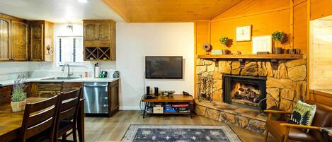 Una sala de estar acogedora con chimenea, muebles de madera y una pared de piedra.