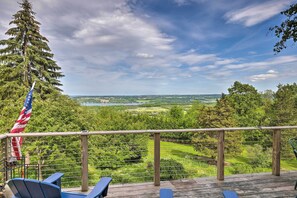 A deck with a view of a golf course, a tall tree, and an American flag. - Spectacular Views w/ Deck, Fire Pit, & Game Room! (Keuka Park)