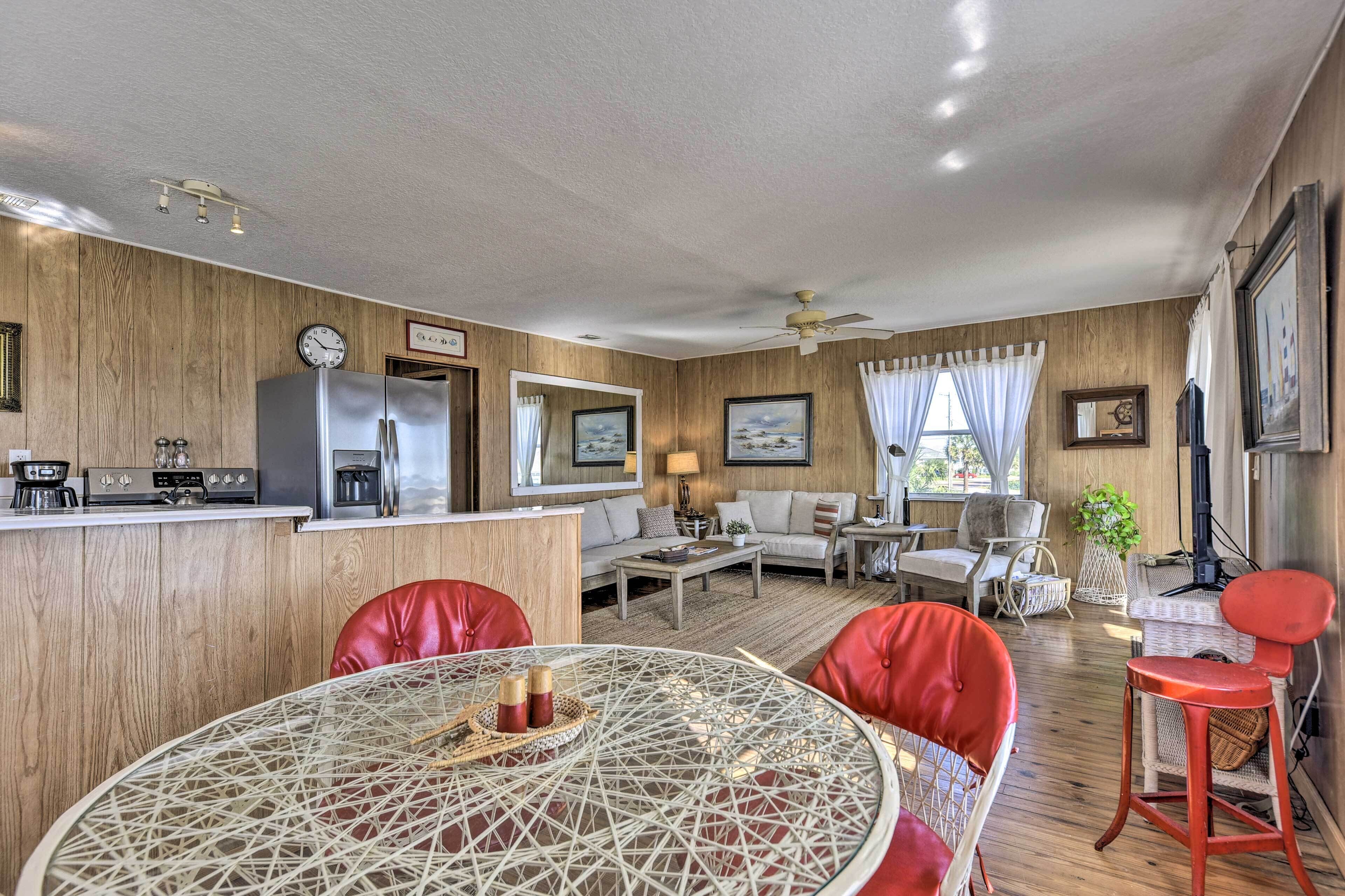 Un espacio habitable compacto con kitchenette, comedor y zona de estar.
