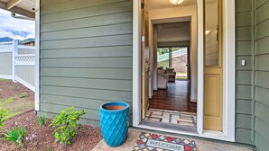 A house entrance with a welcome mat, a blue planter, and a view into the interior. - Modern Waianae Home w/ Mountain & Valley View (Waianae)