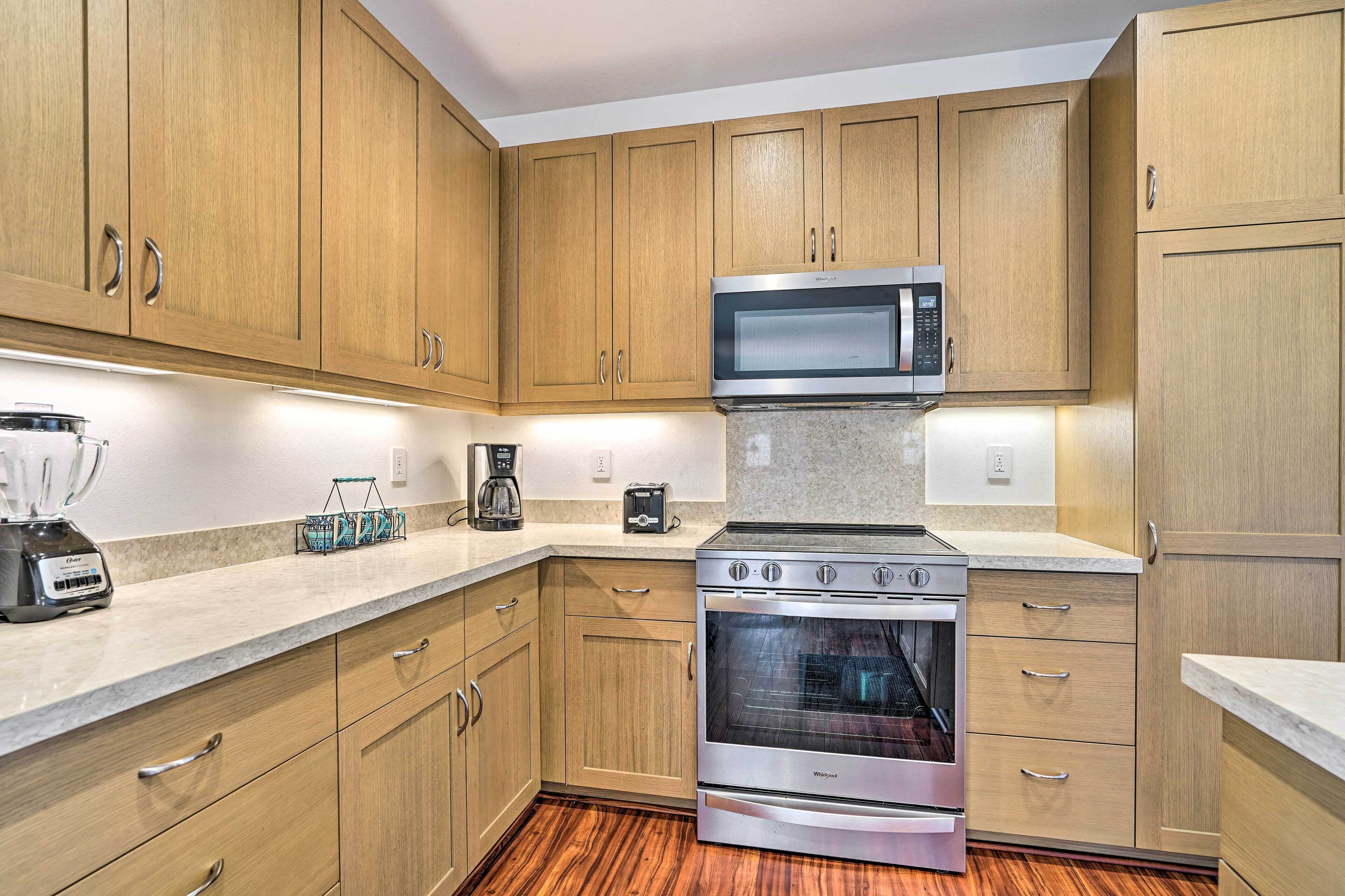 A kitchen with wooden cabinets, a microwave, a coffee maker, and a toaster.